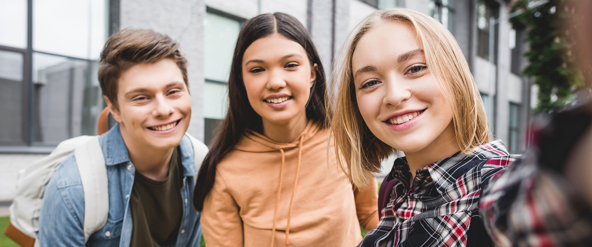 Panoramic shot of happy teenagers taking selfie and smiling - Wellness Psychotherapy