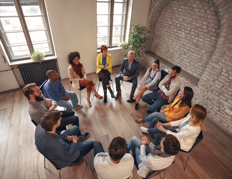 Group of diverse people sitting in a circle talking