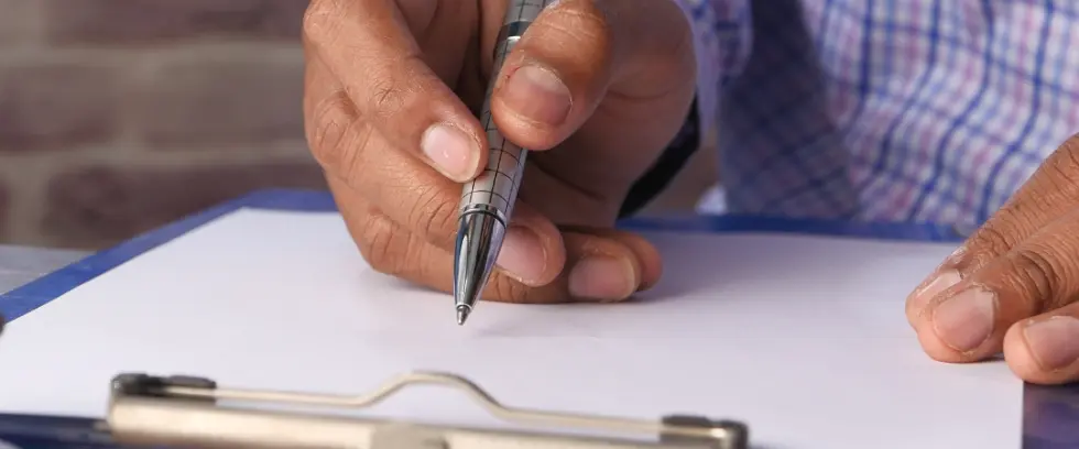 Individual taking notes on a clipboard
